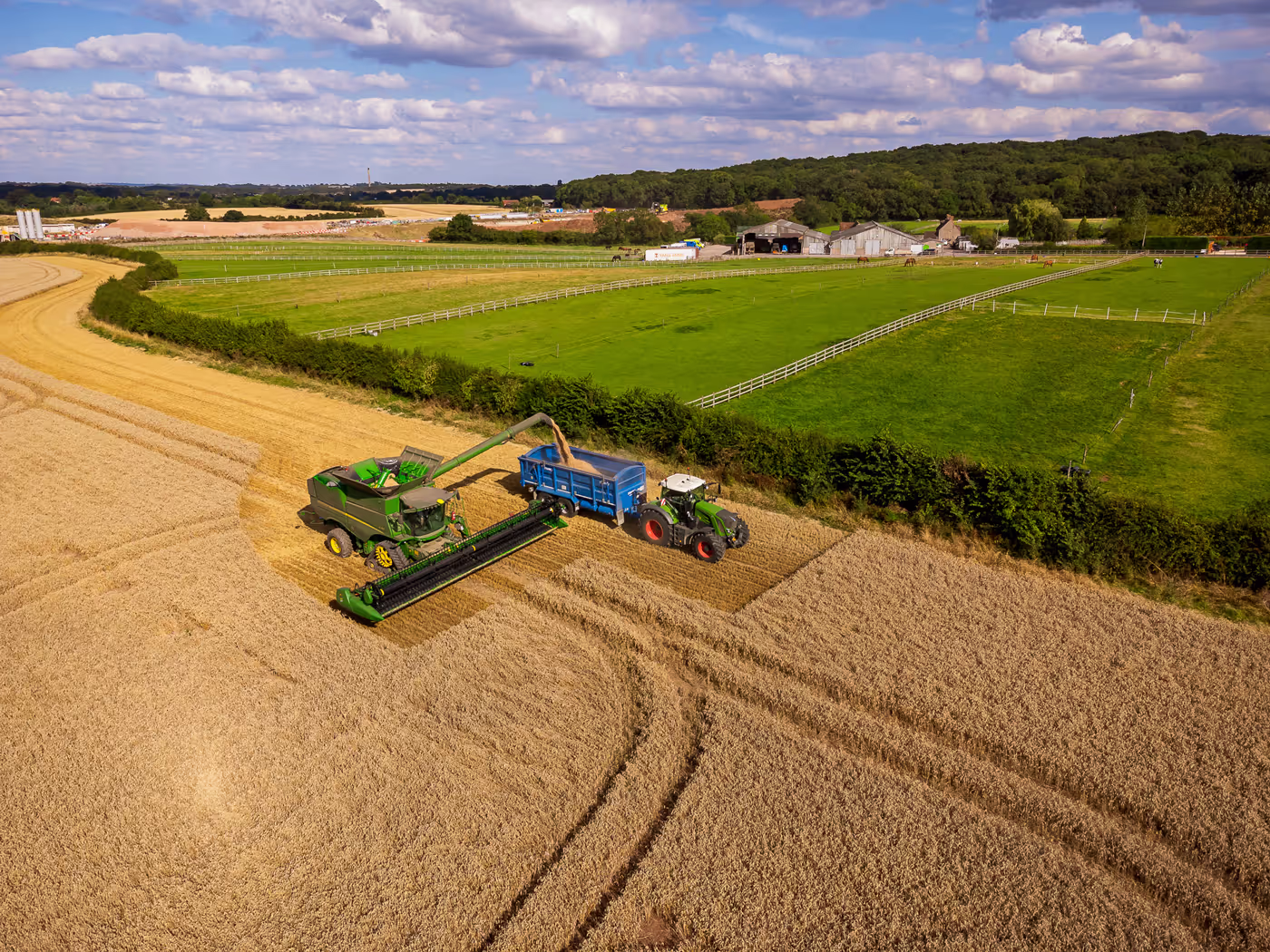 Combine and tractor in field