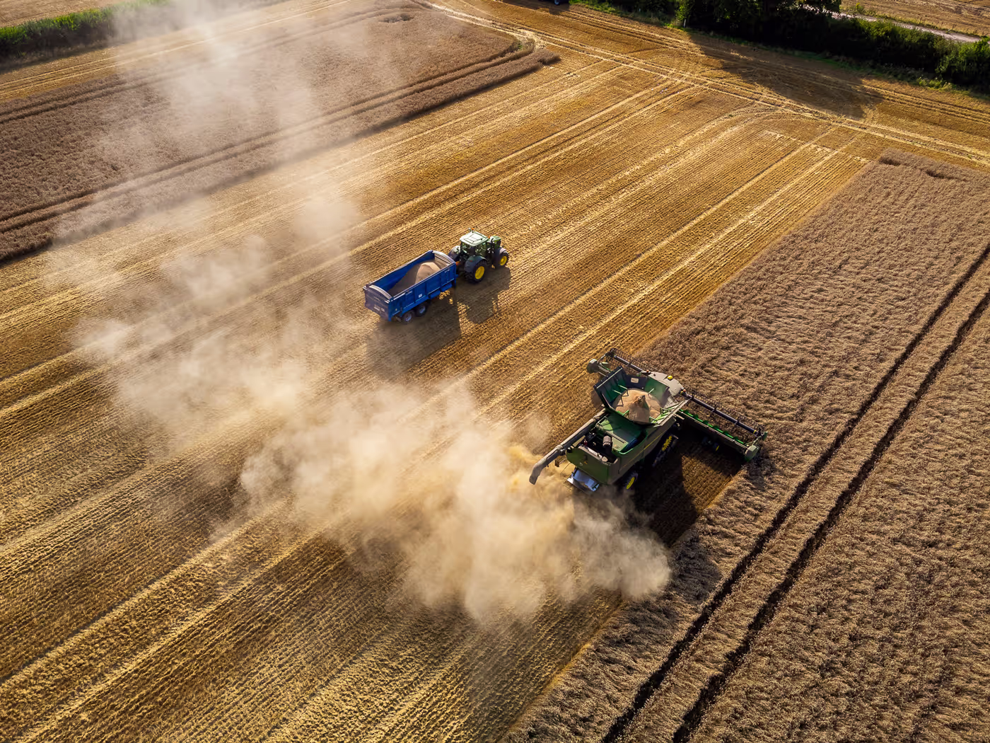 Combine and tractor in field